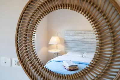 a mirror reflecting a bedroom with a bed in a room at The Sandy Feet Sea Front in Hurghada