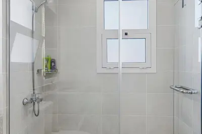 a bathroom with a shower with a glass door at The Sandy Feet Sea Front in Hurghada