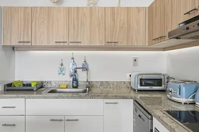 a kitchen with white cabinets and a sink at The Sandy Feet Sea Front in Hurghada