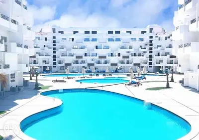 an apartment with a swimming pool in front of a building at Tiba View in Hurghada