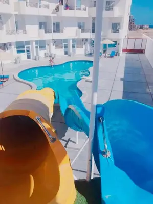 a swimming pool with a water slide in front of a building at Tiba View in Hurghada