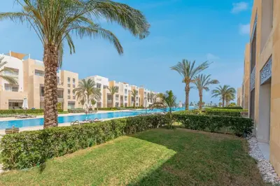 a view of a resort pool with palm trees at Pool Front 2BR in Mangroovy - El Gouna, Beach Access in Hurghada