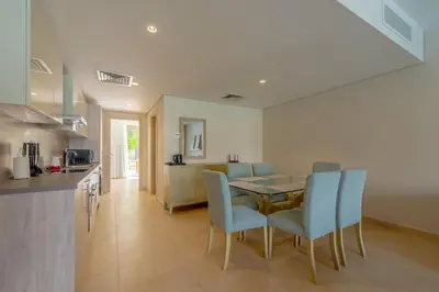 a kitchen and dining room with a table and chairs at Pool Front 2BR in Mangroovy - El Gouna, Beach Access in Hurghada