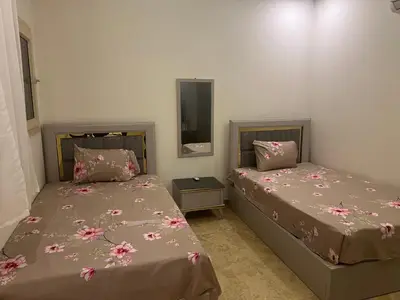 a bedroom with two beds and a mirror at Apartment 2 bedroom and 2 Bathroom pool view at mirage bay in Hurghada