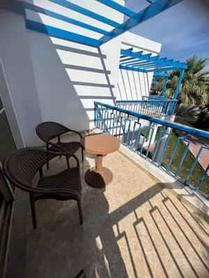 a patio with a table and chairs on a balcony at Apartment 2 bedroom and 2 Bathroom pool view at mirage bay in Hurghada