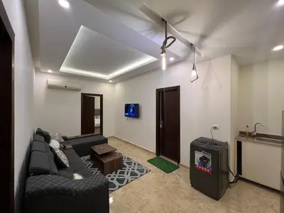 a living room with a couch and a tv at Apartment 2 bedroom and 2 Bathroom pool view at mirage bay in Hurghada