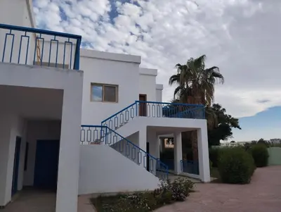 a white house with a blue staircase on it at Apartment 2 bedroom and 2 Bathroom pool view at mirage bay in Hurghada