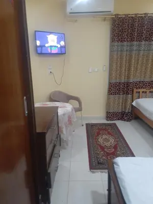 a room with a tv and a bed and a table at Kazpilkna Beach Neighborhoods in Hurghada