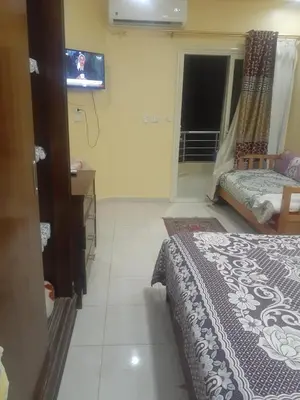 a bedroom with a bed and a tv on the wall at Kazpilkna Beach Neighborhoods in Hurghada