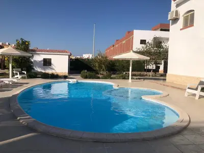 a large blue swimming pool in a courtyard at studio for daily rent in Hurghada