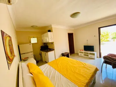 a bedroom with a yellow bed and a kitchen at studio for daily rent in Hurghada