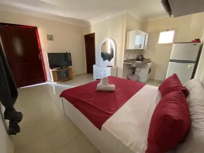 a bedroom with a large bed with a red blanket at studio for daily rent in Hurghada