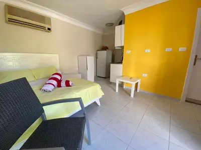 a living room with a bed and a yellow wall at studio for daily rent in Hurghada