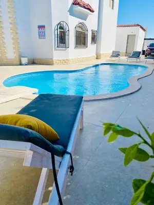 a large swimming pool with a bench in front of it at studio for daily rent in Hurghada