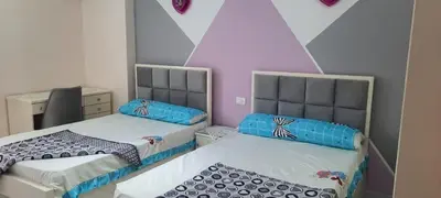 two beds in a small room with pink and blue at New Apartment for short and long term in Hurghada