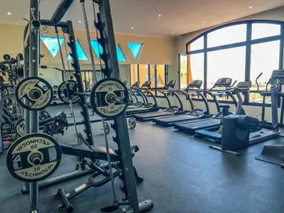 a gym with a row of treadmills and machines at The View Club House in Hurghada