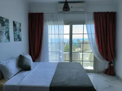 a bedroom with a bed and a large window at Terracotta studio with amazing beach and sea view in Hurghada