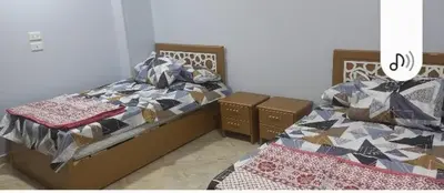 two twin beds in a bedroom withskirts at Ikea flat 10 in Hurghada