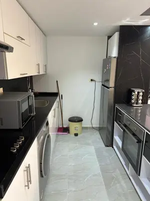 a kitchen with black and white cabinets and a microwave at S 22 Marina City in Port Ghalib
