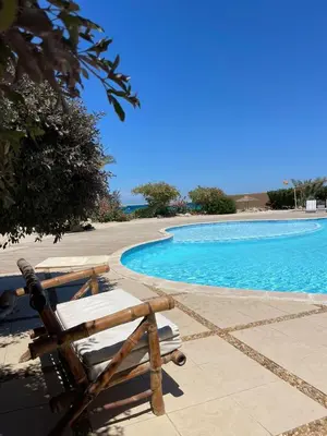 a pair of lounge chairs next to a swimming pool at Studio in old Sheraton in Hurghada