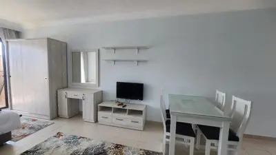 a dining room with a table and a television at Studio in old Sheraton in Hurghada