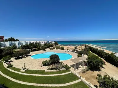 an aerial view of a resort with a swimming pool and the ocean at Studio in old Sheraton in Hurghada