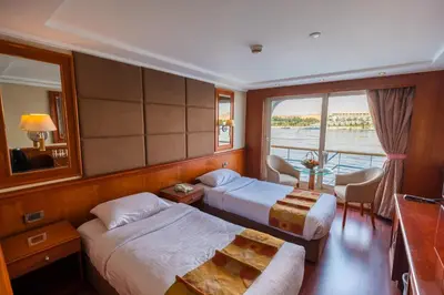 a hotel room with two beds and a balcony at live Nile in style Nile cruise in Luxor and Aswan in Luxor