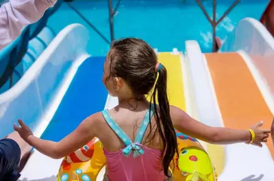 a little girl in an infront of a slide at Hurghada Mirage Bay Hotel & Aquapark in Hurghada