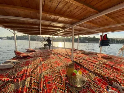 a man on a boat with nets on the water at 2nights Felucca from aswan to komobo temple in Aswan