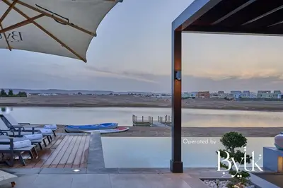 a patio with chairs and an umbrella next to a body of water at BYTK - Casamigos in Hurghada
