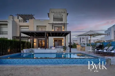 a villa with a swimming pool in front of a house at BYTK - Casamigos in Hurghada