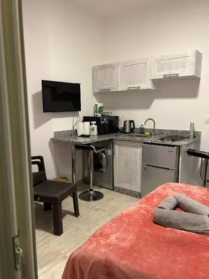 a room with a kitchen and a desk with a computer at Fabulous studio 8 mins drive to El Gouna gates in Hurghada