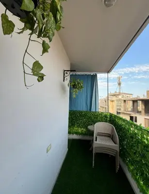 a balcony with a chair and a green hedge at 2 room Appartement in Hurghada