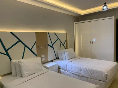 a hotel room with two beds and a closet at Private Room Hurghada for rent beach and pools included Not Valid for Locals in Hurghada