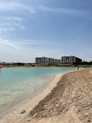a sandy beach with buildings in the background at Private Room Hurghada for rent beach and pools included Not Valid for Locals in Hurghada