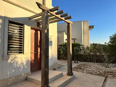 a wooden pergola in front of a house at El Gouna Cyan Villa with pool n lagoon by BFG Beit Fel Gouna in Hurghada