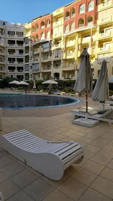 a mattress bed next to a swimming pool in a building at Florenza Khamsin Apartments in Hurghada