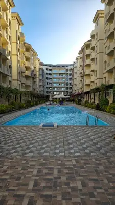a large swimming pool in front of some apartment buildings at Florenza Khamsin Apartments in Hurghada