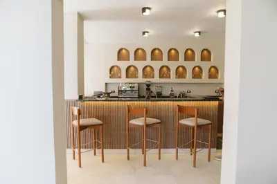 a kitchen with a bar with four stools at TK Royal & Spa in Hurghada