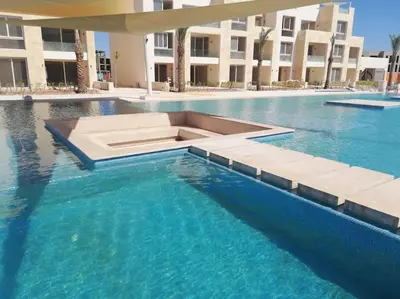 a swimming pool with blue water in a building at Cozy Ground floor-Pool view - Mangroovy El Gouna in Hurghada