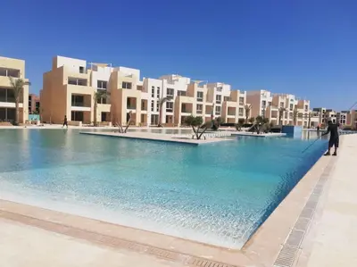 a large pool of water with buildings in the background at Cozy Ground floor-Pool view - Mangroovy El Gouna in Hurghada