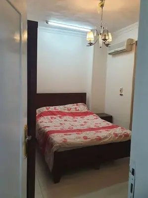 a bedroom with a bed with a red comforter at Hurghada city center in Hurghada