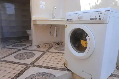 a washing machine in a bathroom with a sink at Happy house in Luxor