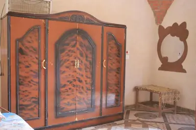 a large wooden cabinet in a corner of a room at Happy house in Luxor