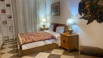 a bedroom with a bed with a lamp and a chair at Sheraton Plaza Retreat in Hurghada