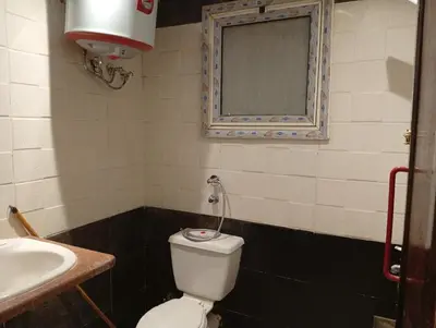 a bathroom with a toilet and a sink and a mirror at Sheraton Plaza Retreat in Hurghada