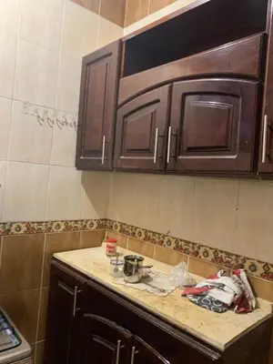 a kitchen with wooden cabinets and a counter top at Welcome to LLL (Love Life Luxor) in Luxor