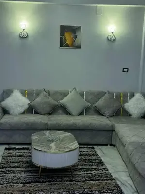 a living room with a gray couch with pillows at Luxurious Studio Apartment. in Luxor