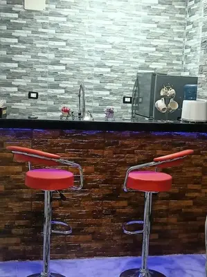 two red bar stools in front of a counter at Luxurious Studio Apartment. in Luxor