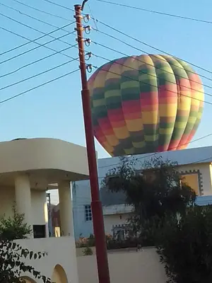 a colorful hot air balloon flying over a house at Luxor Palm Villa in Luxor